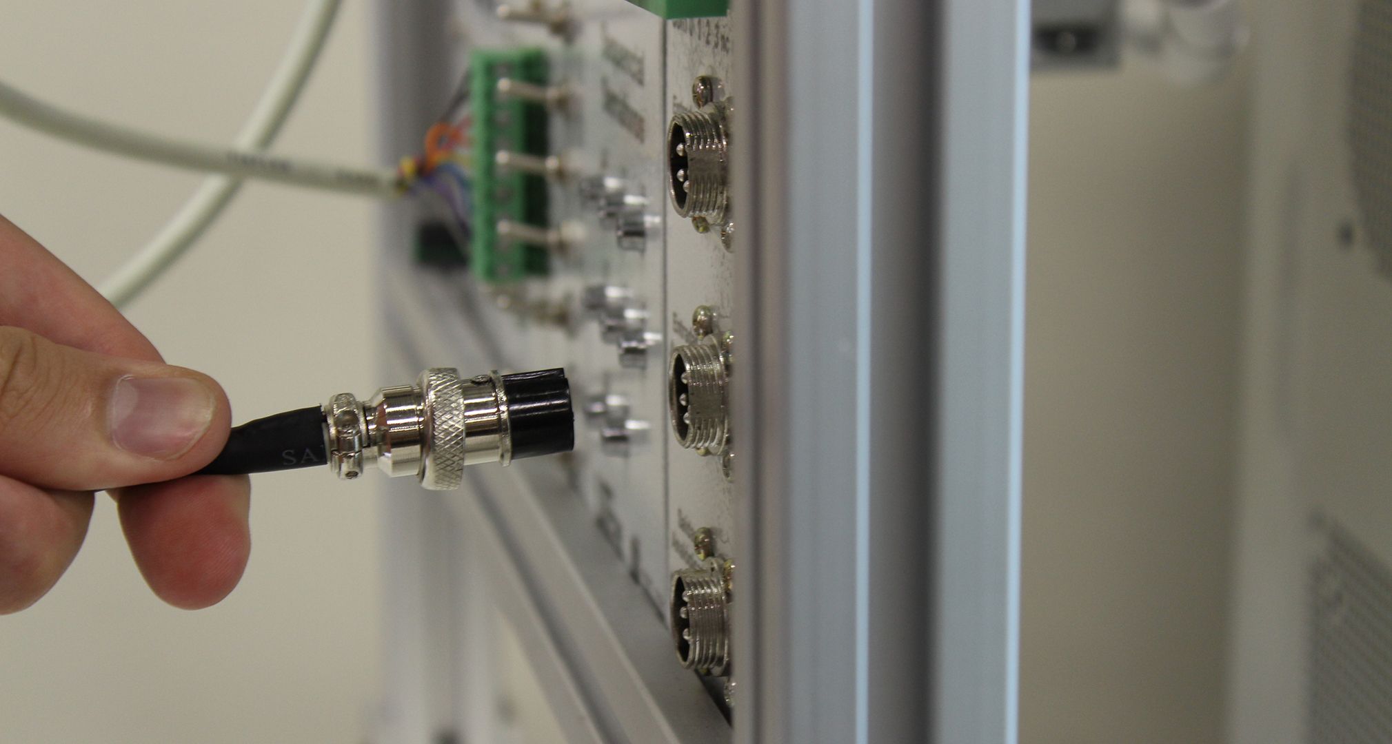Image of a cable beeing connected to a test-bench